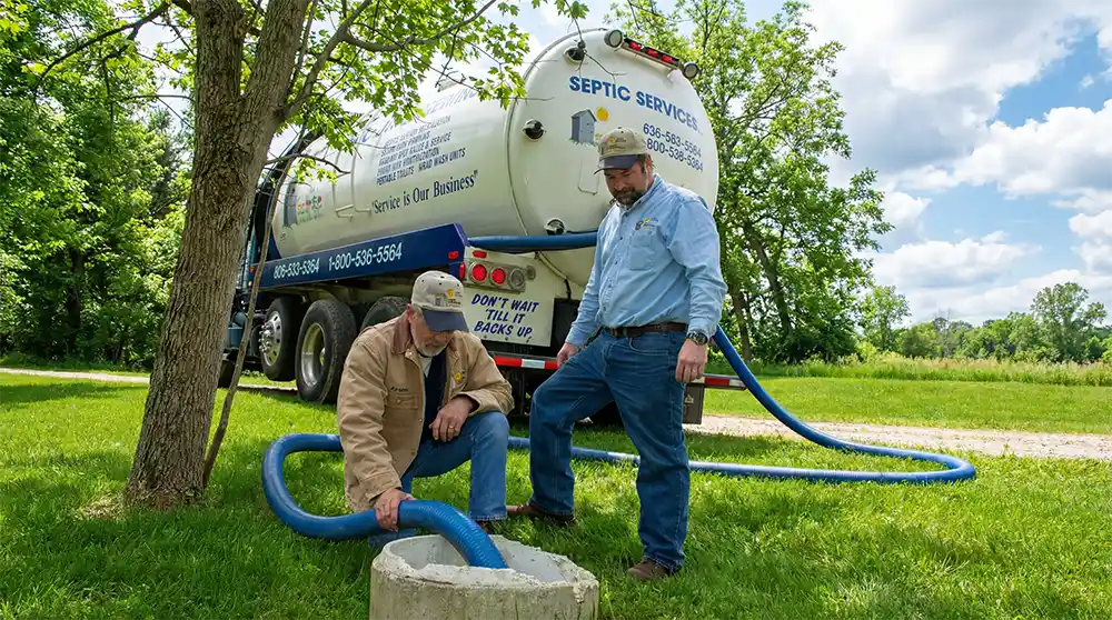 2 workers pumping a septic tank